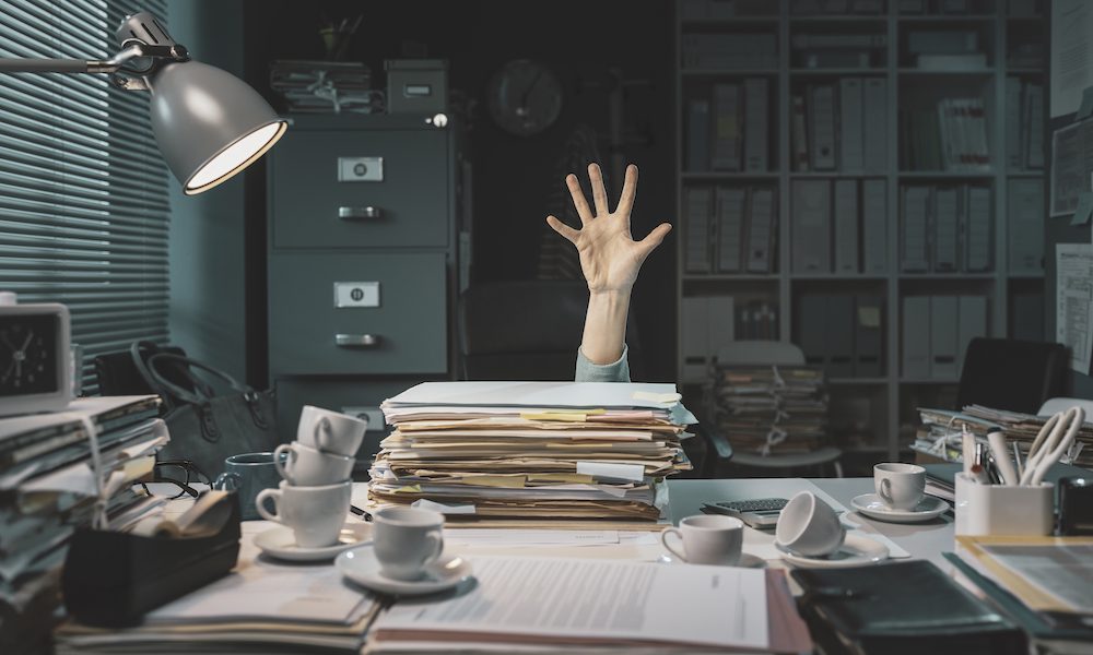 Office worker overwhelmed with paperwork